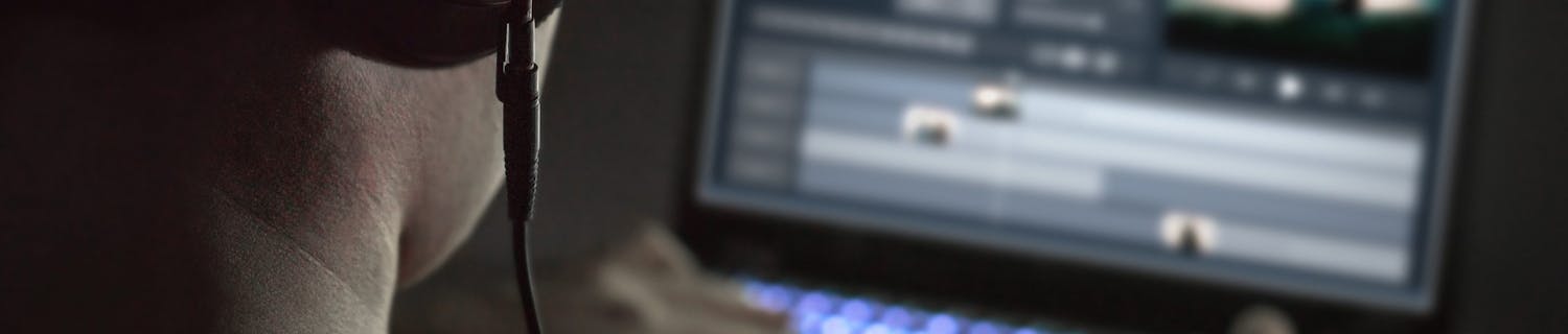 Mies muokkaa videota tietokoneellaan.